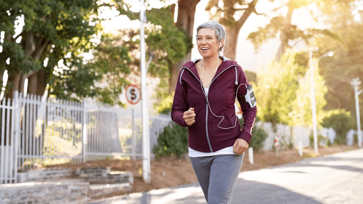 Woman running tree lined street