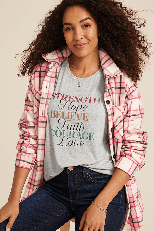 A woman modeling a graphic t-shirt that reads, 